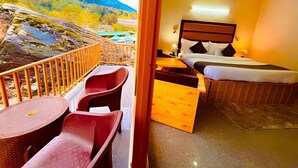 Une chambre d’hôtel avec un balcon, un lit, un bureau et une chaise.