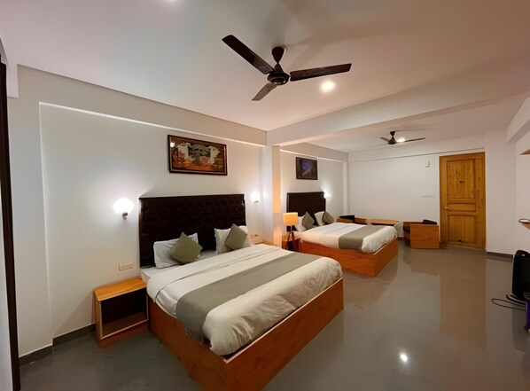 A modern hotel room with two beds, a ceiling fan, and artwork on the walls. - Hotel beas river retreat (Manali)