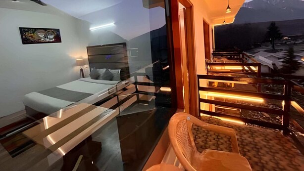 Une chambre à coucher moderne avec un lit, une table de chevet et une vue sur les montagnes.