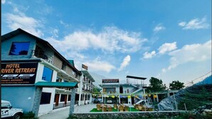 Un hôtel appelé « Hotel River Retreat », avec une enseigne indiquant qu’il propose des services de déjeuner et de dîner.