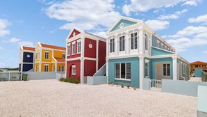 A colorful beachfront property with multiple buildings, each with distinct architectural styles and colors.