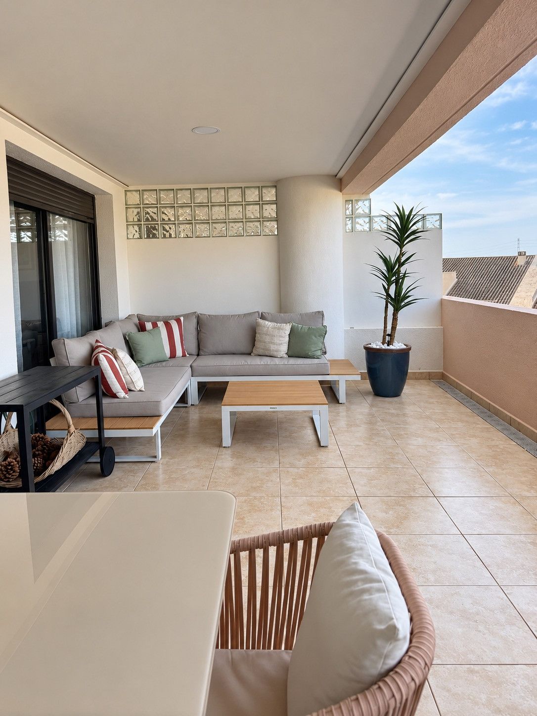 A balcony with a sofa, a table, and a chair.