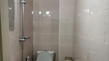 Bañera con ducha, toallas, jabón, papel higiénico