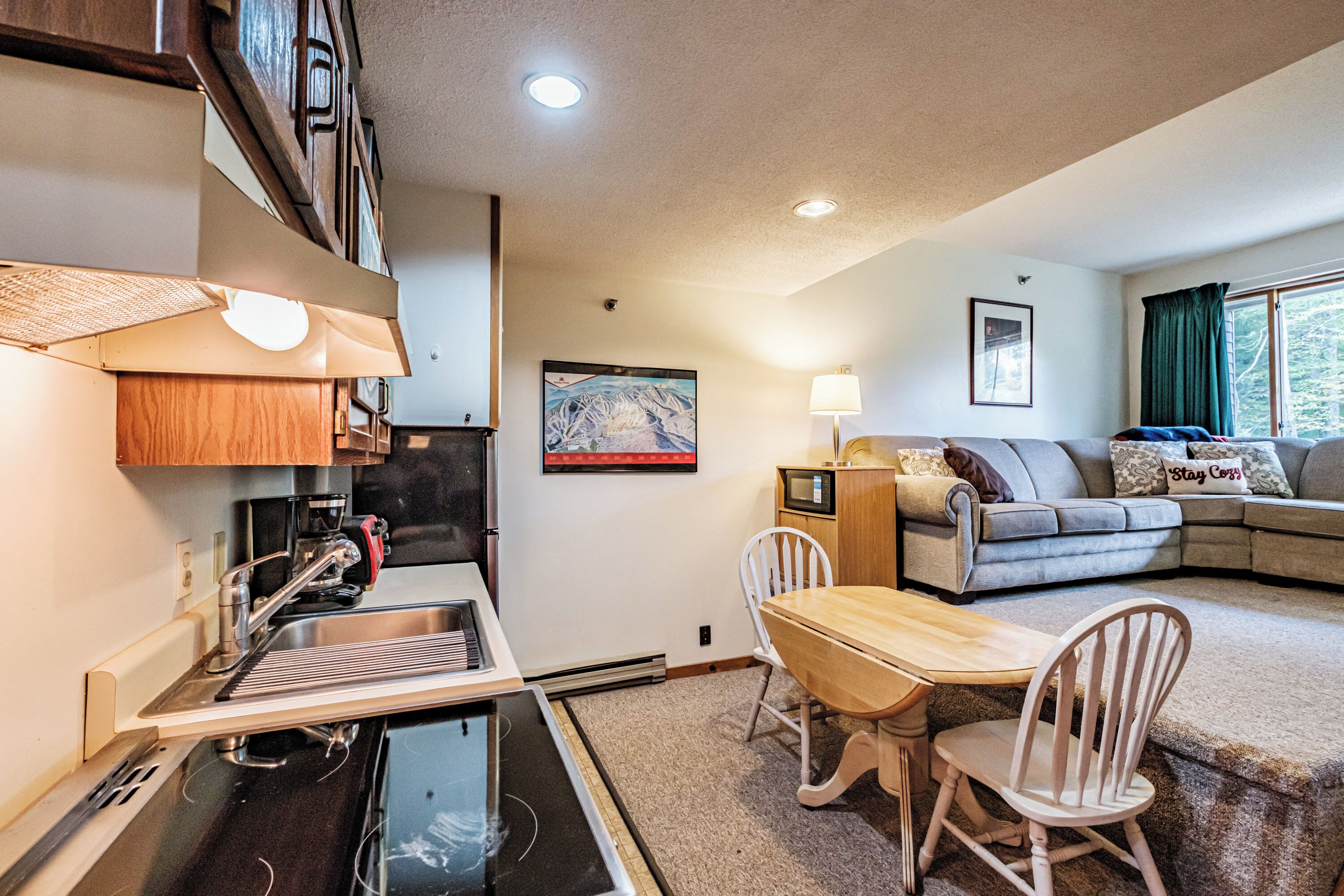 A compact living space with a kitchenette, dining area, and seating area.
