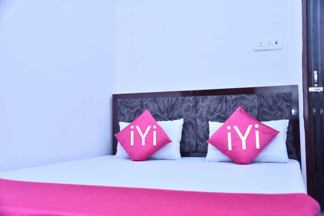 A bed with two pillows, each with a pink pillowcase and the letters "iYi" printed on them.