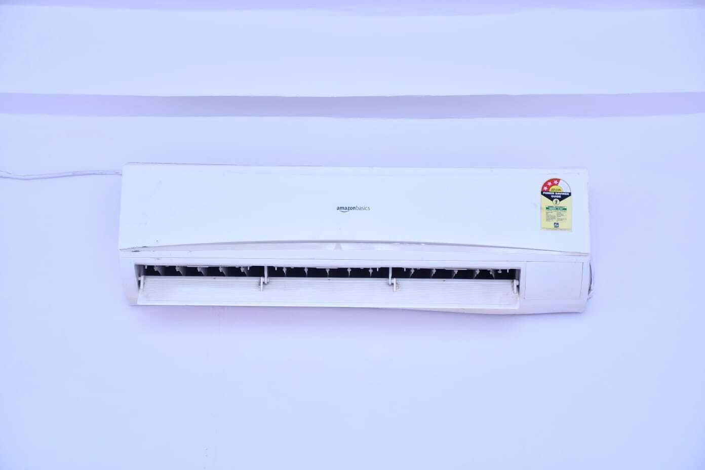 A white wall-mounted air conditioning unit with a visible brand logo and a certification sticker.