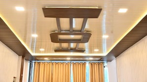 Un plafond moderne doté d’un éclairage encastré et d’un luminaire central.