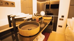 Une salle de bain moderne avec un grand lavabo rond, un miroir et un meuble-lavabo.
