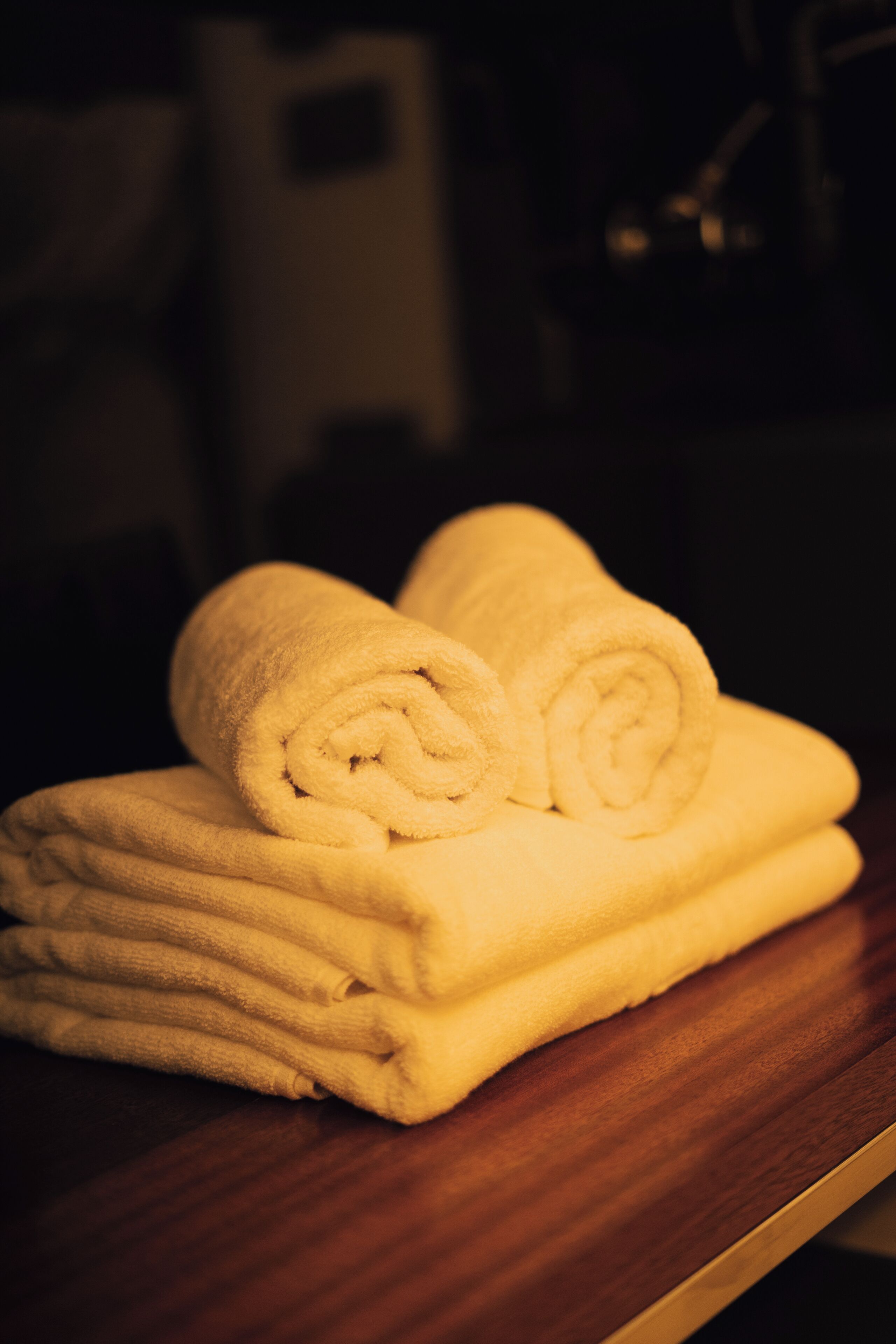 A stack of neatly folded yellow towels on a wooden surface.