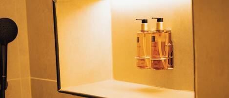 Une salle de bain avec un miroir, deux flacons de savon liquide et un microphone.