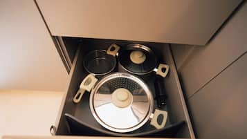 Een keukula met een deksel, een pan en een waterkoker.