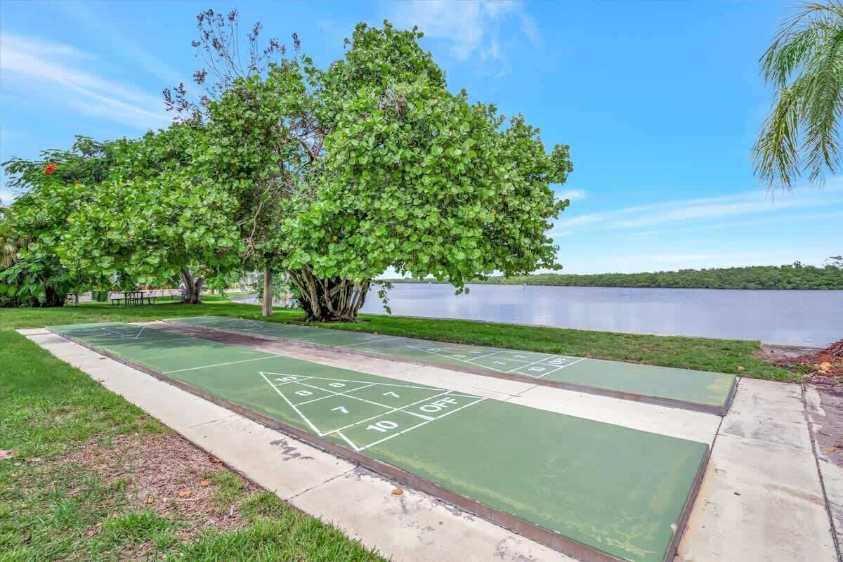 Una cancha de shuffleboard con vista al lago, rodeada de árboles.