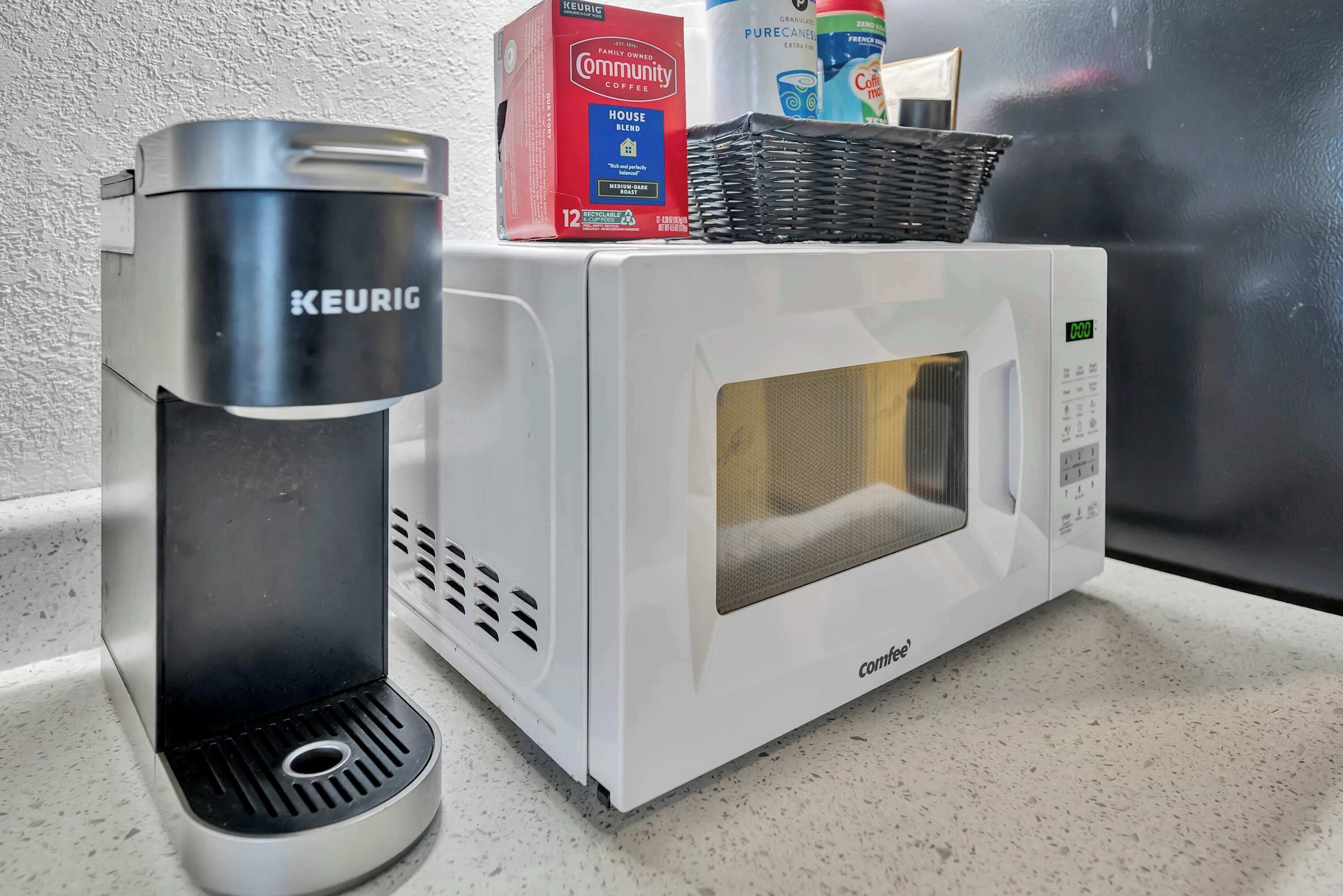 Een koffiezetapparaat en magnetron op een aanrecht.