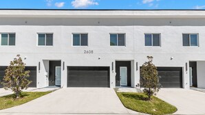 Un bâtiment moderne doté d’un toit plat, portant le numéro 2608, avec une entrée centrale et plusieurs portes de garage.