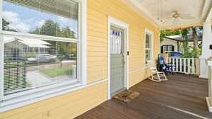 A covered porch with a wooden deck, a white door, and a ceiling fan. - NEW Lakeland Landing Cute Bungalow by Downtown (Lakeland)