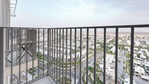 A balcony with a view of a cityscape, featuring modern buildings and roads. - Dubai Hills Sleeps 2 With Private Balcony (Dubai)