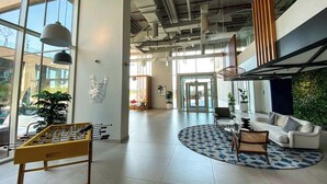 A spacious lobby with a foosball table, comfortable seating, and large windows allowing natural light.
