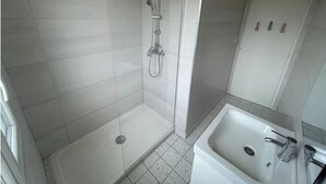 A bathroom with a shower, a sink, and a toilet. - Chill & relax (Limoges)
