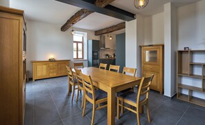 Une cuisine moderne avec une table et des chaises en bois, un four encastré et une fenêtre.