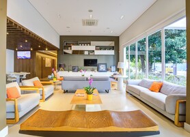 Una sala de estar moderna con sofás, una mesa de centro y un televisor montado en la pared.