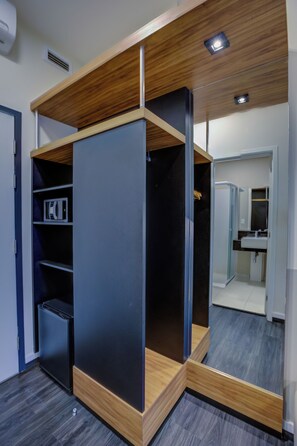 Ein modernes Zimmer mit Einbauschrank, Mikrowelle und angrenzendem Badezimmer.