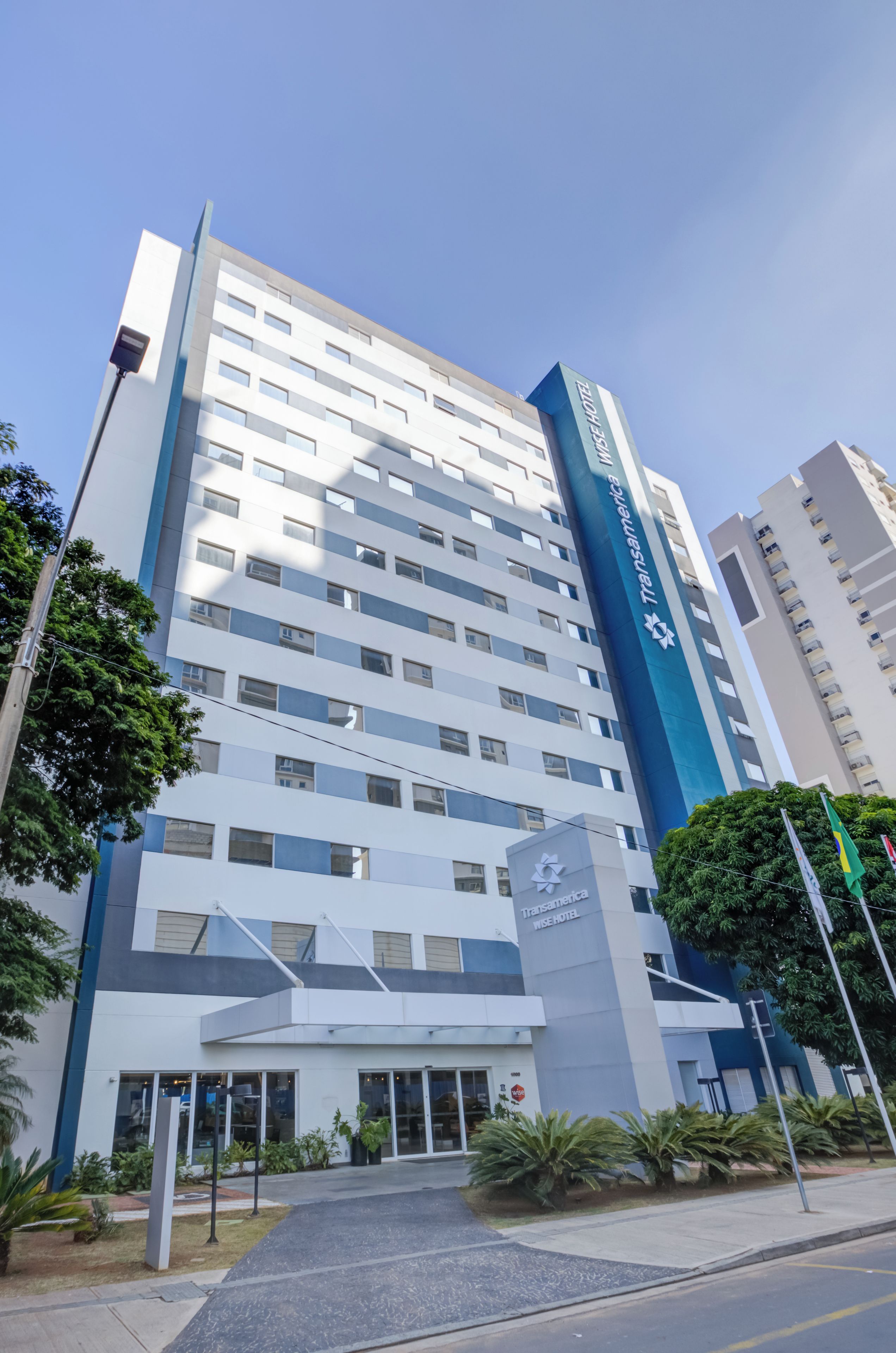 Um edifício de hotel moderno com entrada destacada e céu claro.