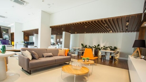 A modern interior with a sofa, round coffee table, and orange chair.