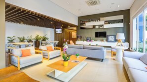 Un salon moderne avec un canapé, une table basse et des plantes.