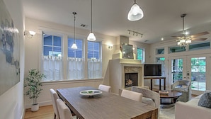 A spacious living area with a wooden dining table, white chairs, a sofa, and a ceiling fan. - 5BR Retreat in Bouldin Creek | Walk to SoCo (Austin)