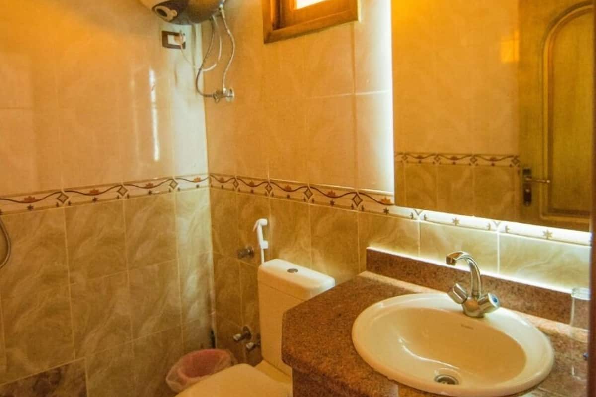 A bathroom with a toilet, sink, and shower.