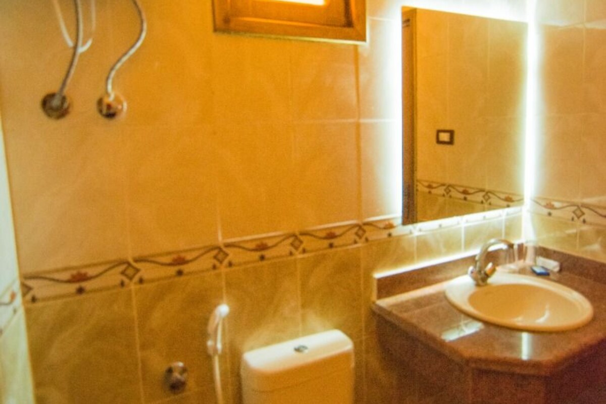 A bathroom with a toilet, sink, and shower.