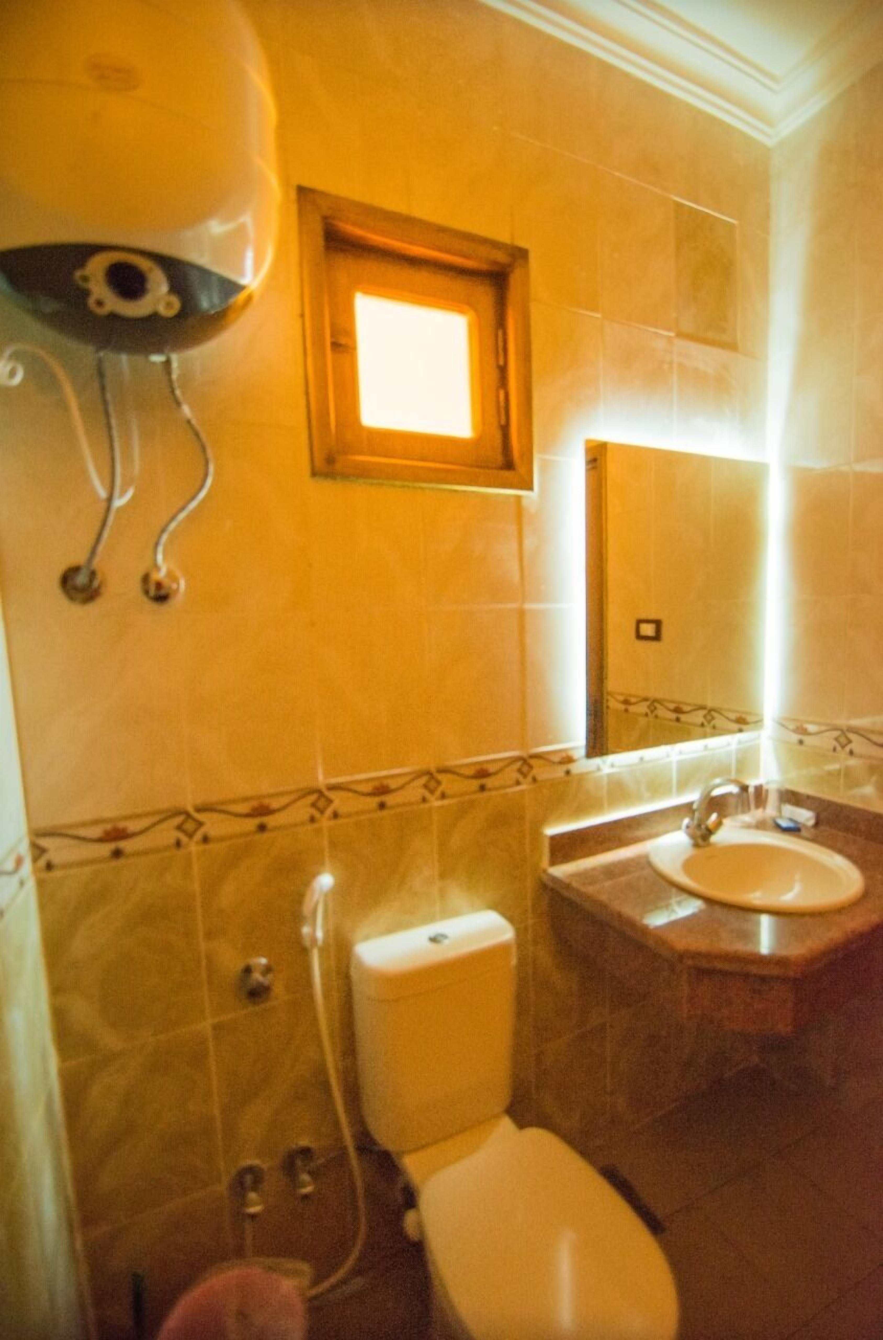 A bathroom with a toilet, sink, and shower.