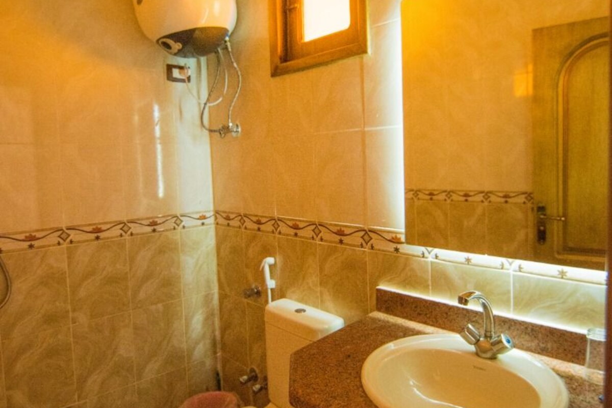 A bathroom with a toilet, sink, and shower.