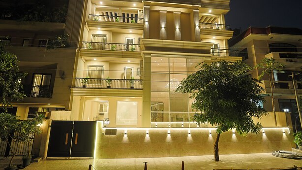 A multi-story building with balconies, large windows, and a well-lit entrance. - Millora Cyber Suites (Gurugram)