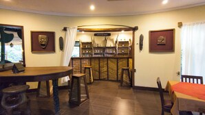 Zona de bar con mobiliario de madera y pared de ladrillo.