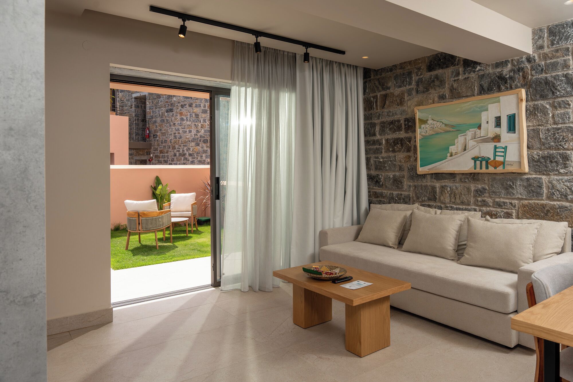 A modern living room with a sofa, a coffee table, and a painting on the wall.
