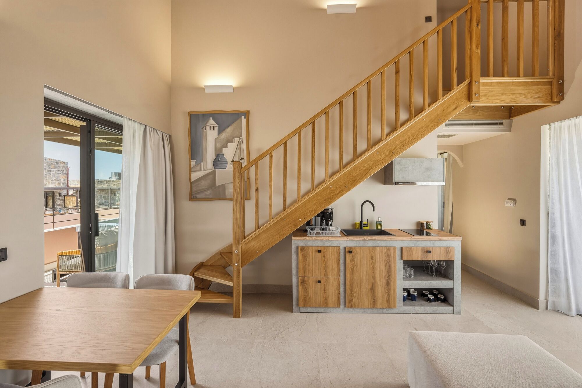 A modern interior with a wooden staircase, a dining area, and a kitchen with a built-in wine rack.