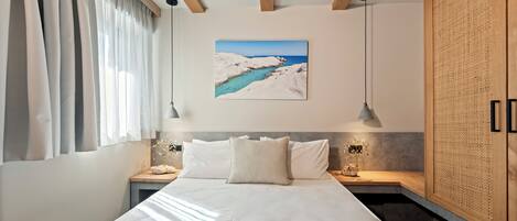 A bedroom with a bed, bedside tables, a painting, and a large window with curtains.