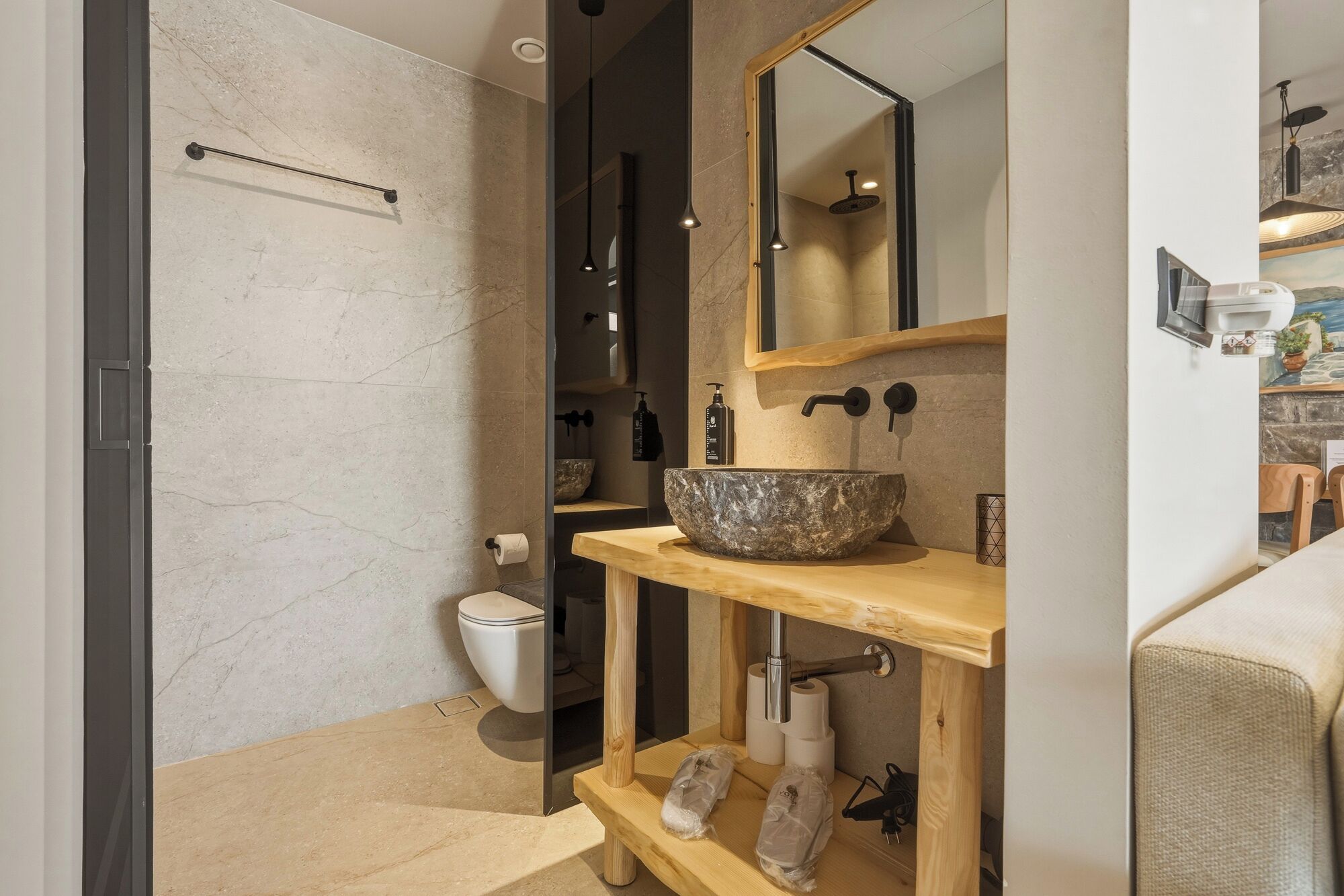 A modern bathroom with a large basin, a toilet, and a shower area.
