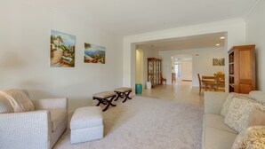 A spacious living room with a beige carpet, two sofas, a coffee table, and a dining area in the background. - Resort Perks & Office! spacious Palm Springs Home (Palm Springs)