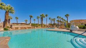 A clear blue swimming pool with palm trees and a building in the background. - Resort Perks & Office! spacious Palm Springs Home (Palm Springs)