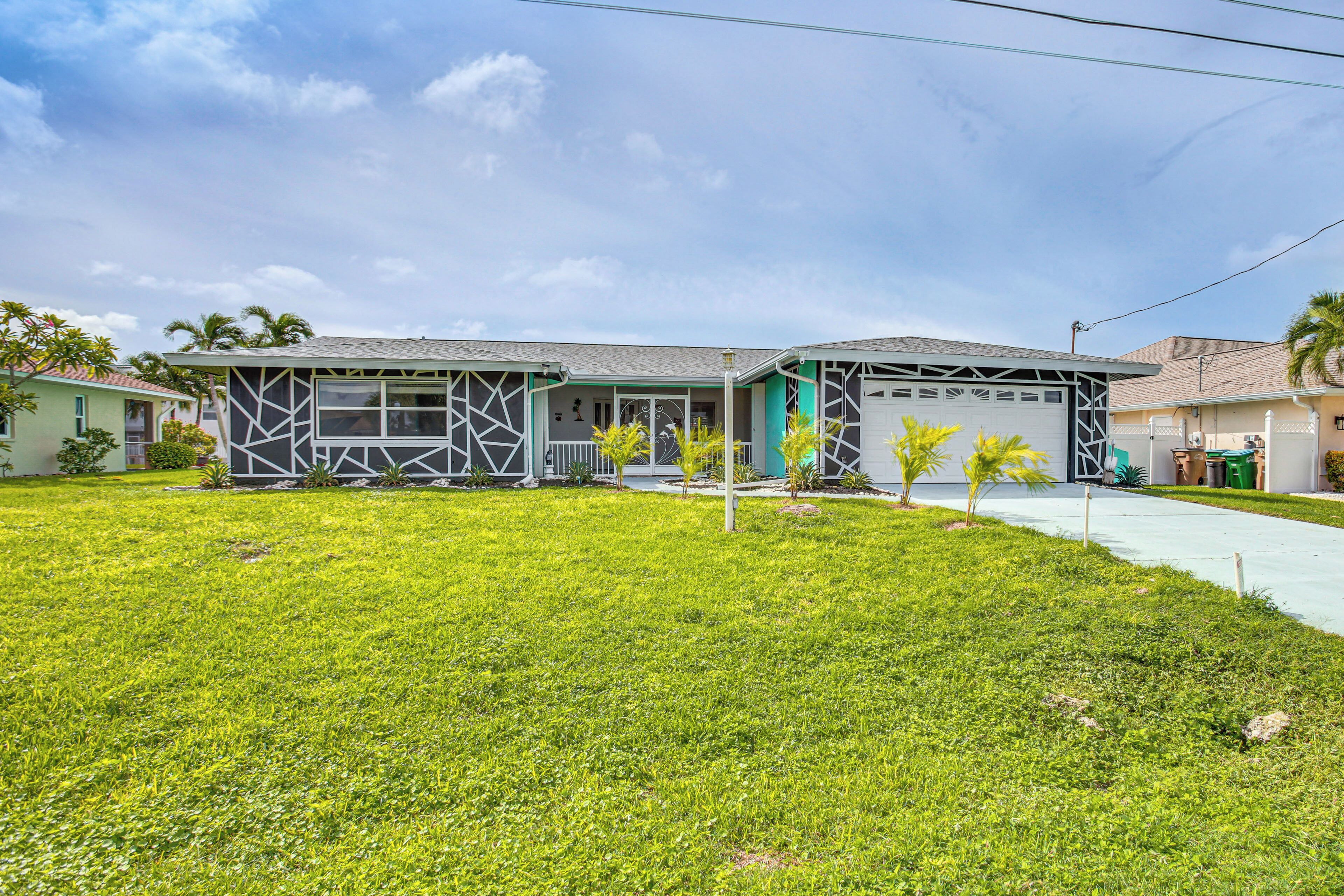 A modern two-story house with a garage, a well-maintained lawn, and a clear sky.