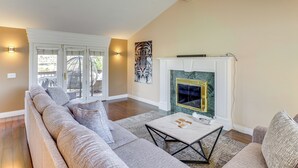 A living room with a sofa, coffee table, fireplace, and a painting on the wall. - Big Space, Bigger View! Cottonwood Canyon Retreat (Salt Lake City)
