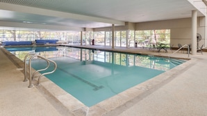 An indoor swimming pool with clear water, a diving board, and a seating area with tables and chairs. - 1 Mi to Vail Ski Resort: Condo w/ Resort Perks! (Vail)