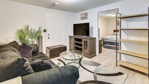 A living room with a sofa, coffee table, TV, and a bookshelf. - < 2 Mi to Umass Health & Dtwn: Traveling Pros Hub (Worcester)