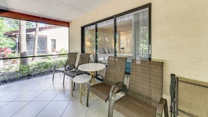 A covered outdoor seating area with chairs and a table, large windows, and a view of the outdoors. - 4 Mi to Siesta Beach: Condo w/ Community Perks! (Sarasota)