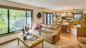 Ein geräumiges Wohnzimmer mit einer Ledersofa, einem Holztisch und einem Essbereich mit Holztisch und Stühlen.