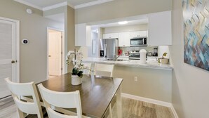 A modern kitchen with white cabinets, stainless steel appliances, and a central island with seating. - 2 Mi to Ocean! Poolside Escape in Miramar Beach (Miramar Beach)