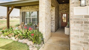 A house with a stone exterior, a covered porch, and a front door. - 11 Mi to Texas Tech University: Cozy Family Home! (Wolfforth)
