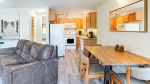 A modern kitchen with wooden cabinets, a white refrigerator, and a dining area with a wooden table and chairs. - 1 Mi to Stagecoach Chairlift: Stateline Condo (Stateline)